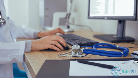 Healthcare professional working with clinic management software at a computer station.