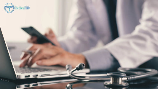 Doctor using clinic management software on a laptop with stethoscope nearby.